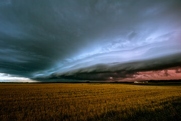 Late evening angry shelf cloud over old abandoned farm