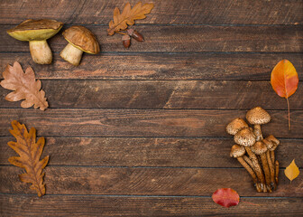 Flat lay composition with fresh mushrooms and leaves on wooden table with copy space. Autumn background.