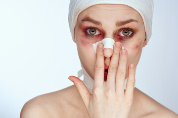 woman with bandaged face bruises syringe in hand painkillers light background