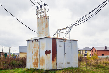 A large transformer booth with wires in a country village.