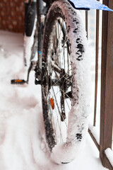 Bike with adhered snow on wheels at winter season, close up view