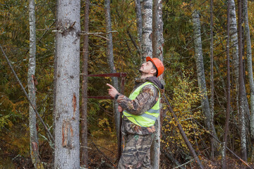 Forest worker works in the forest with a measuring tool. Real people work.