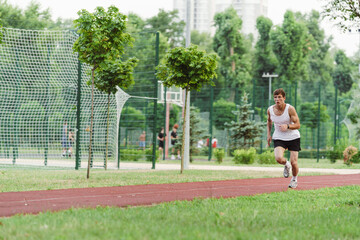 Young white sportsman running while working out on playground