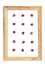Christmas background with falls red small balls in wooden painted frame isolated in white.