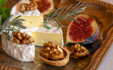 Cheese with white mold on a silver tray.