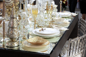 Festive xmas new year table setting with beautiful tableware and decor in shiny shining golden colors