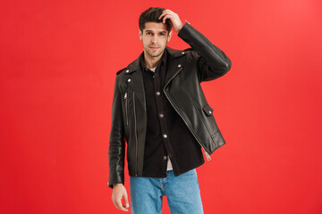 Young unshaven man wearing leather jacket looking at camera