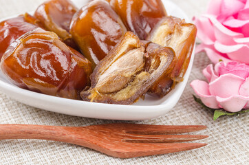 Dried dates fruit in white bowl.