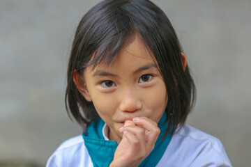 Portrait of a Vietnamese young little cute girl sucking her finger