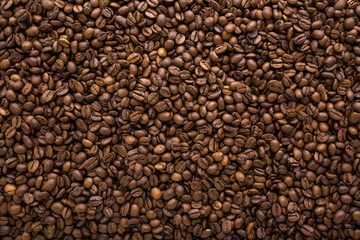 Fresh dark brown coffee beans background. Closeup. Empty place for text. Top down view.