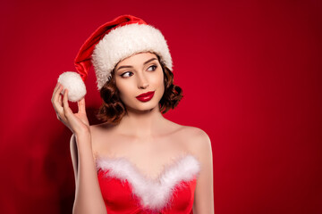 Photo of dreamy cool happy lady look empty space hold ball hat christmas eve isolated on gradient red color background