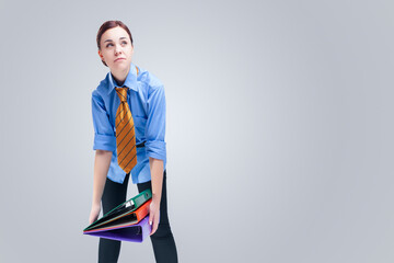 Businesspeople Concepts. Young Brunette Caucasian Woman in Official Blue Shirt and Tie Posing With Heap of Folders.