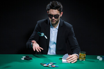 Gambling Concepts. Caucasian Young Handsome Pocker Player Staking and Betting To Win At Pocker Table With Chips And Cards.
