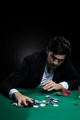 Nervous Concentrated Handsome Caucasian Brunet Young Pocker Player At Pocker Table With Chips And Cards