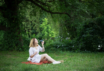 young woman blowing bubbles in the park