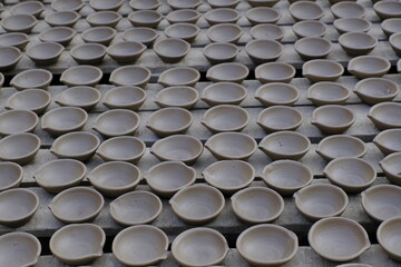 A potter prepares clay lamp for festival celebration, Terracotta diyas or oil lamps for Diwali.