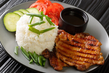 Broken Rice Recipe with Grilled Pork Chop close-up in a plate on the table. Horizontal