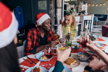 People sit at a festive table and celebrate new year's eve or Christmas.