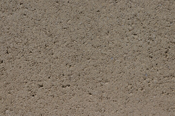 Street wall with plaster. Plaster of beige color with holes. Decorative render. Wall texture. High quality photo