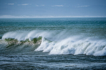 Beautiful early morning ocean waves with spray been blown by strong winds.