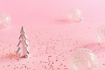 Decorative Christmas tree and transparent balls on pink background with colorful star shaped confetti. Minimal Christmas background