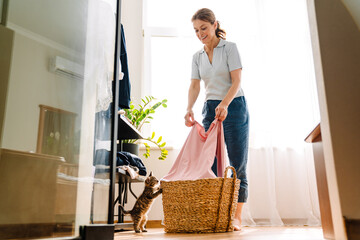 Ginger mature woman playing with kitten while doing housework © Drobot Dean