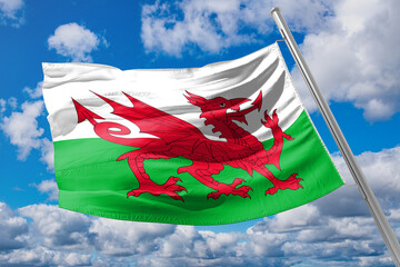 The Welsh flag against a blue sky. Motion blur at the tip of the flag. Space for text in the sky.