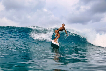 Mid adult woman surfing on water during vacation