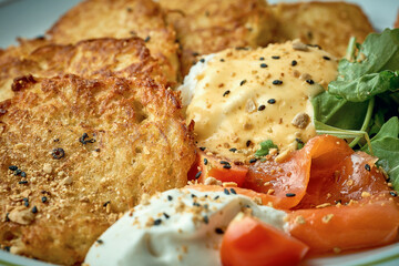 Fried potato pancakes with poached egg and lightly salted salmon. Hashbrown, dranik