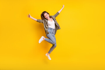 Fototapeta na wymiar Full length photo of excited satisfied girl open mouth have fun jumping isolated on yellow color background