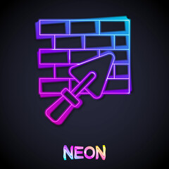 Glowing neon line Brick wall with trowel icon isolated on black background. Vector