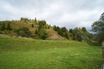 Haystack in the mountains on a background of green grass