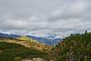 View from the top of the mountain to the mountains, forests, stone ledges. Clouds in the mountains. Wild nature background