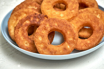 Fried curd donuts in a blue plate close up