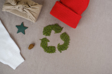 Recycling sign with Christmas tree needles. Winter recycling clothes. Top view or flat lay. High quality photo