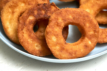 Fried curd donuts in a blue plate close up