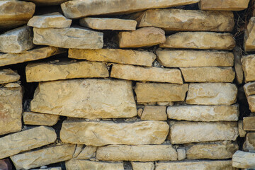The texture of ancient historical masonry wall made of different sizes of stones without the use of cement.