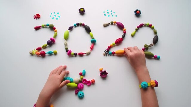 The inscription 2022 made of multicolored beads on a white background