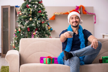 Obraz na płótnie Canvas Young man celebrating Christmas at home