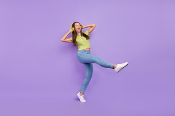 Fototapeta na wymiar Full length body size view of pretty overjoyed carefree cheerful girl listening rock dancing isolated over purple violet color background