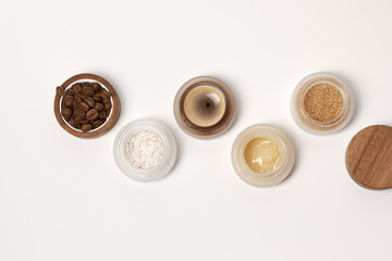 Brown sugar, coffee and honey ingredients for scrub in glass jars with wooden lid for homemade cosmetic on background. Beauty, Spa, skin care, zero waste packaging concept
