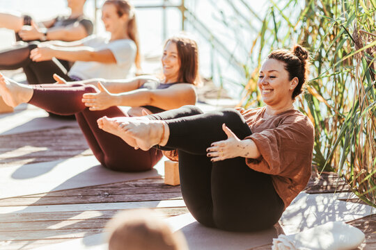 Smiling women practicing yoga on exercise mat