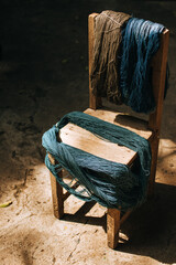 Indigo-dyed threads on a wooden chair. Cotton that has been dyed in its natural color.