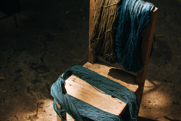 Indigo-dyed threads on a wooden chair. Cotton that has been dyed in its natural color.