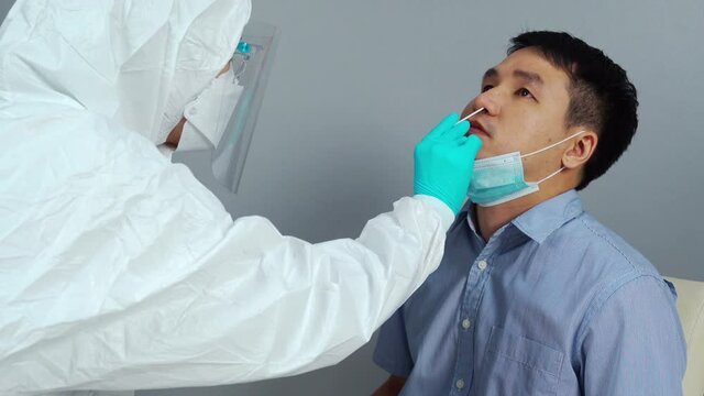 doctor with PPE suit test coronavirus(covid-19) to patient by nasal swab
