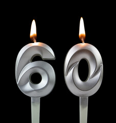 Burning silver birthday candle isolated on black background, number 60