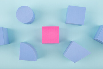 Concept of individuality and being different from others in blue colors. Pink cube and blue...
