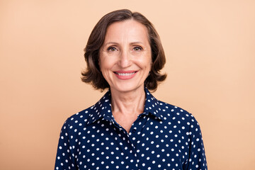 Photo of friendly old brunette lady wear blue shirt isolated on beige color background