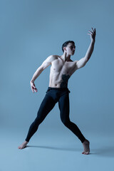 Obraz premium Young and graceful male ballet dancer isolated on old navy studio background. Art, motion, action, flexibility, inspiration concept.