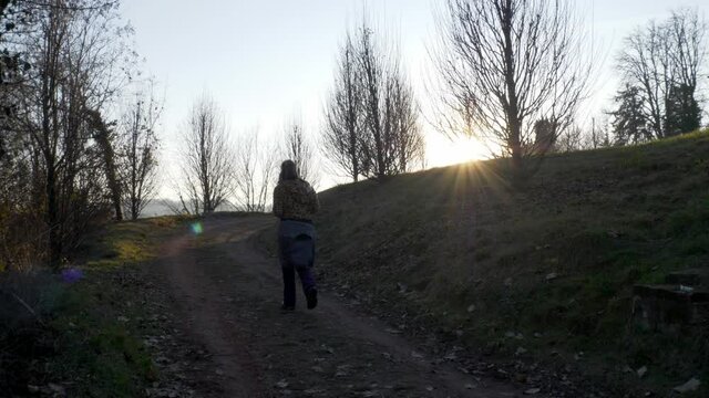 Woman silhouette walks in the hill path. Slow Motion 4K